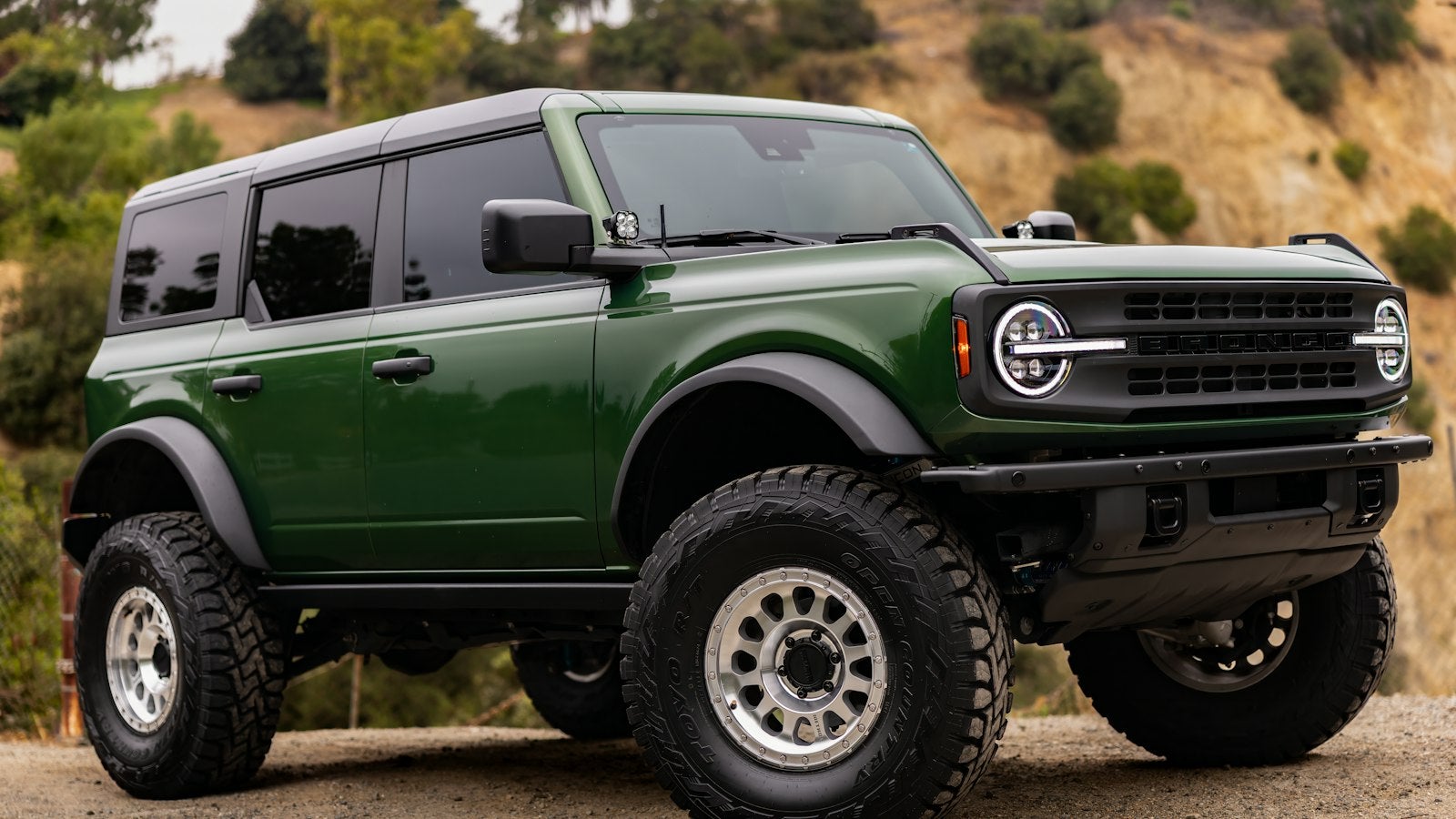 Green Ford Bronco 4-door on a dirt hillside
