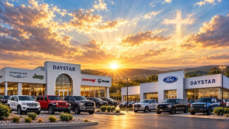 Daystar dealership at sunrise with a cross in the sky